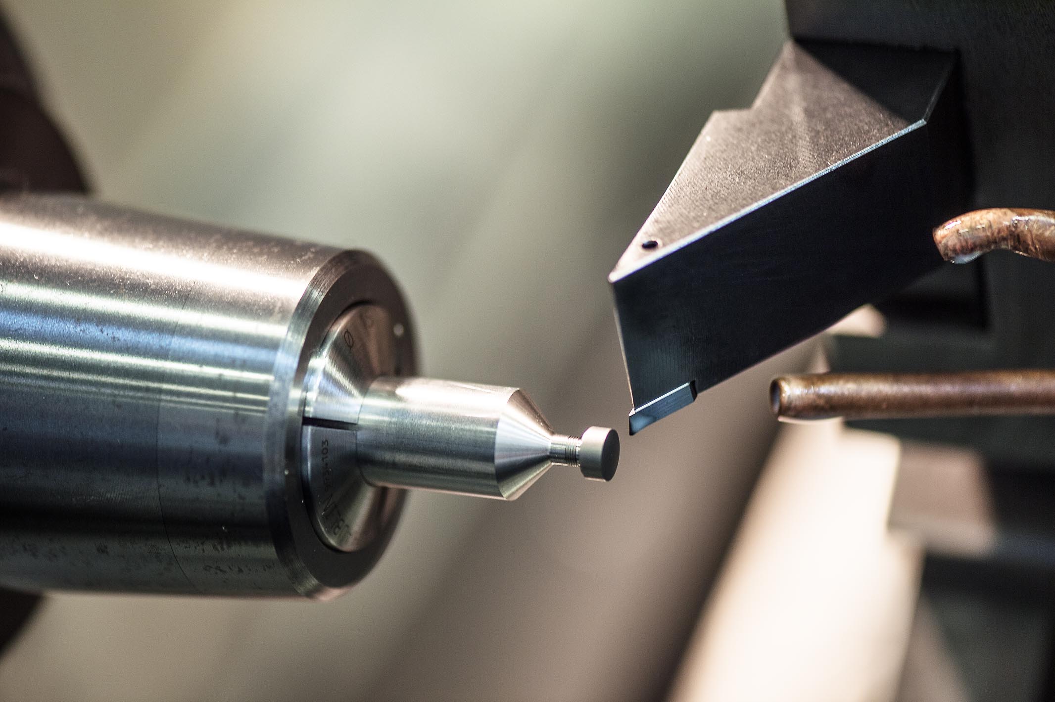 The crown is being turned. For this process, it is screwed on a special mandrel using the existing fine thread. Turning expert Raffel Müller is responsible for ochs und junior’s rotative parts.