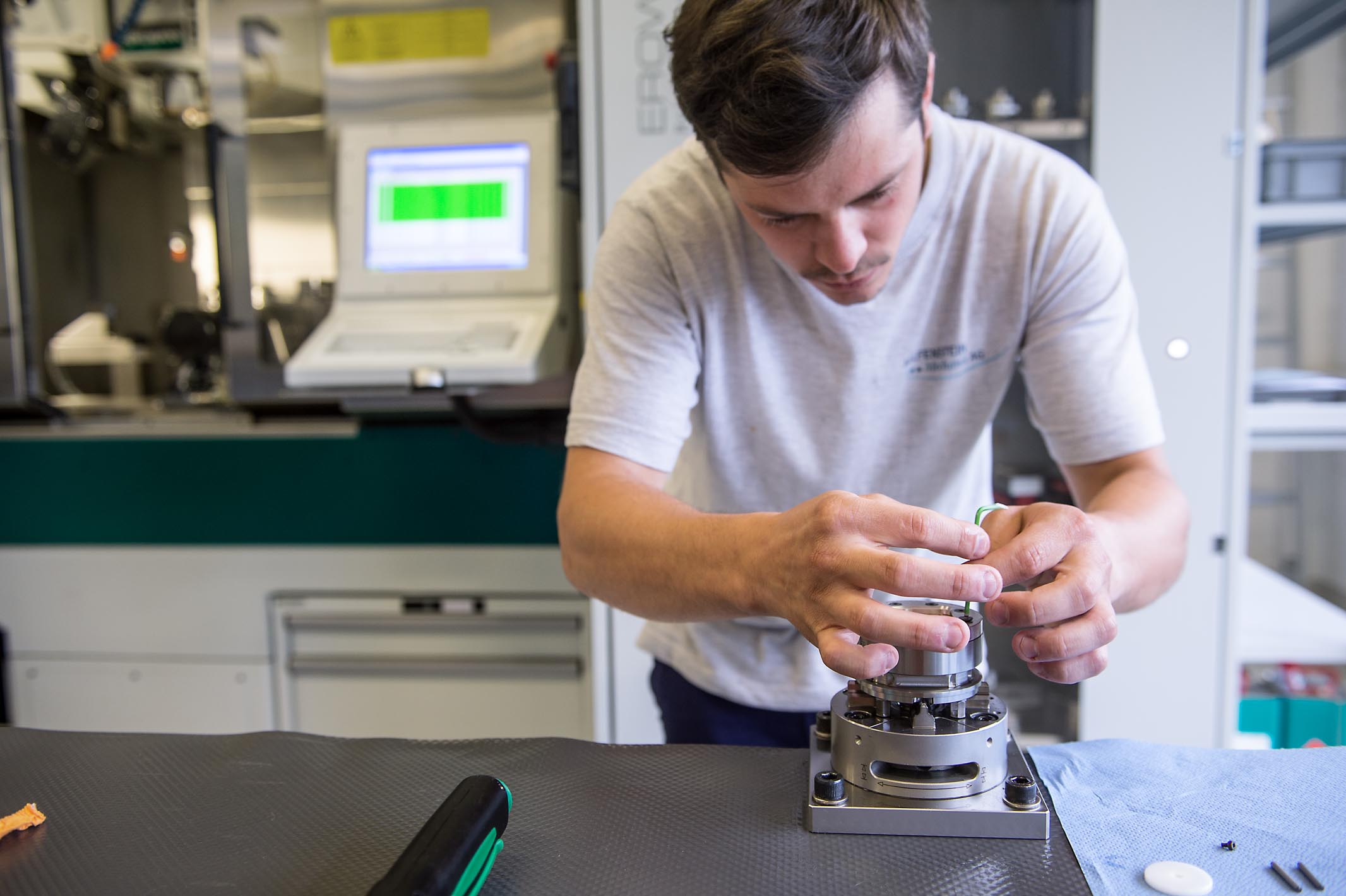 Daniel Matter tightens the screws, which are positioned in a circle, as evenly as possible to make sure the tension in the clamp is even.