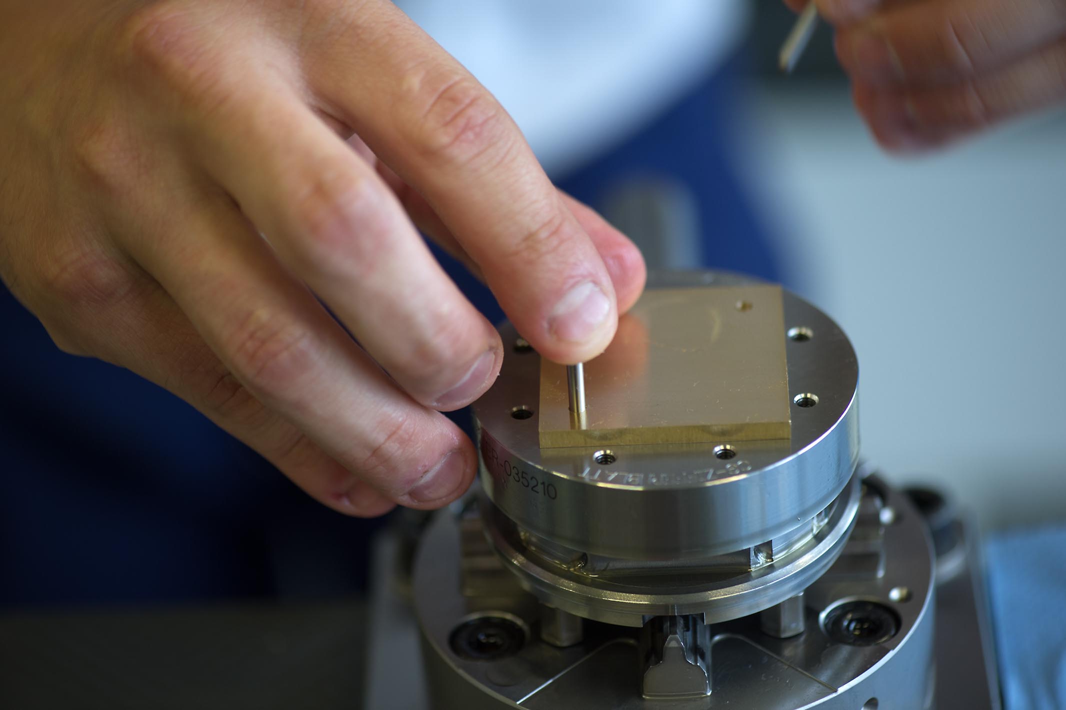 Daniel Matter turns the blank and positions it precisely by means of the pegging holes which he placed when first clamping the blank. These steps require precision and flair, since the dial is lying face down on the device.
