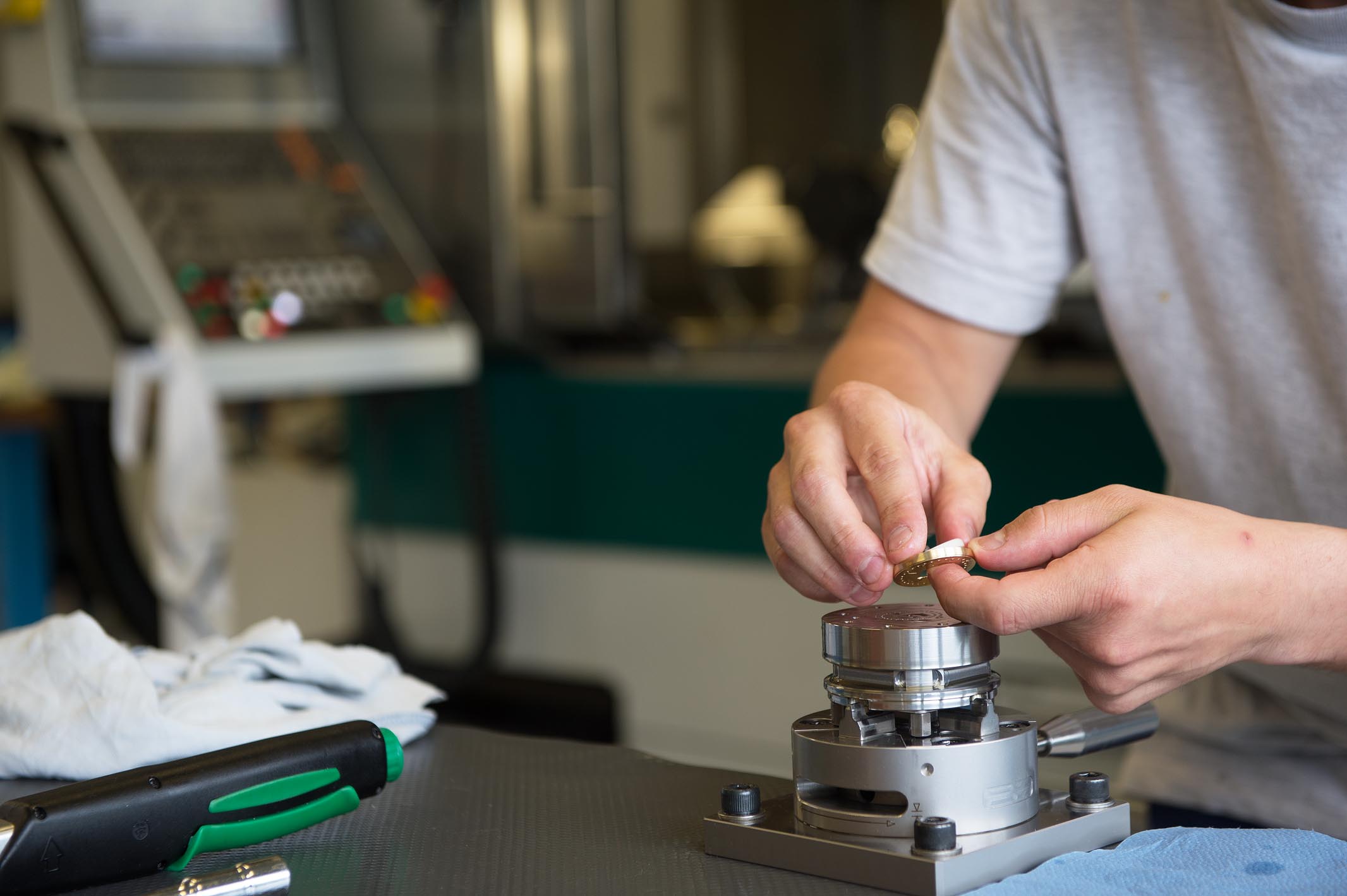 Daniel Matter carefully lifts the dial off the clamping device in order to prevent scratches.